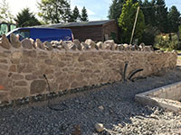 A new 'rubble' stone wall built as part of an enclosed courtyard on a Grade II* Listed building in Picklescott, Shropshire